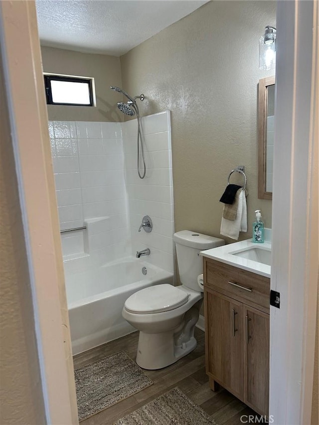 full bathroom with toilet, shower / bathing tub combination, a textured ceiling, vanity, and hardwood / wood-style floors