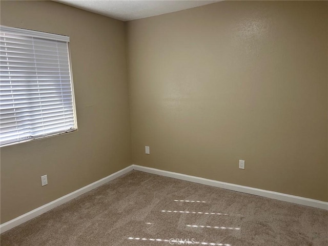 empty room with carpet and baseboards