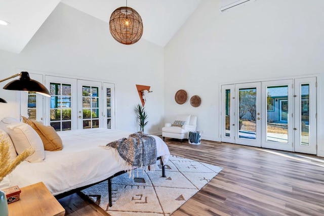 bedroom featuring multiple windows, hardwood / wood-style flooring, access to outside, and french doors