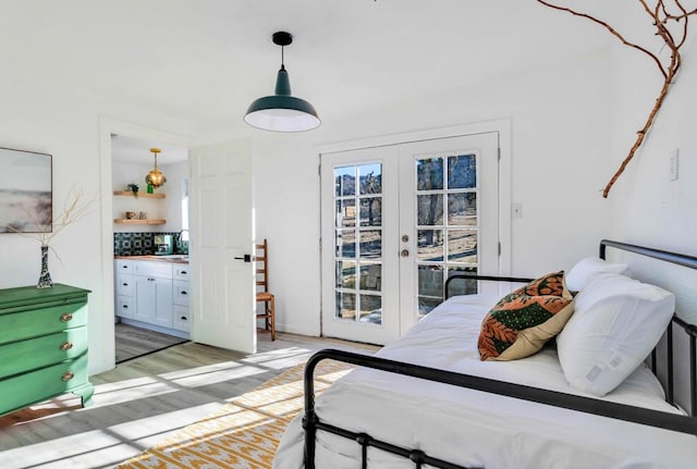 bedroom featuring hardwood / wood-style floors, sink, access to outside, ensuite bath, and french doors