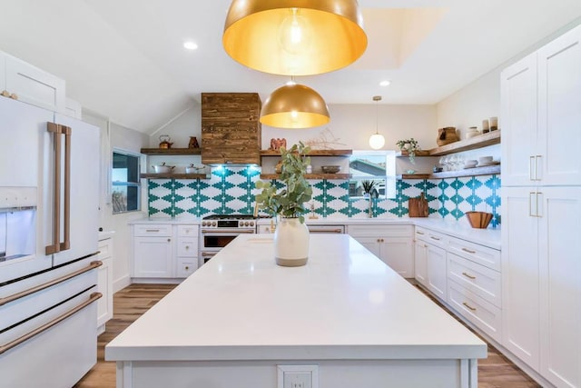 kitchen with white cabinetry, a kitchen island, premium appliances, and decorative light fixtures