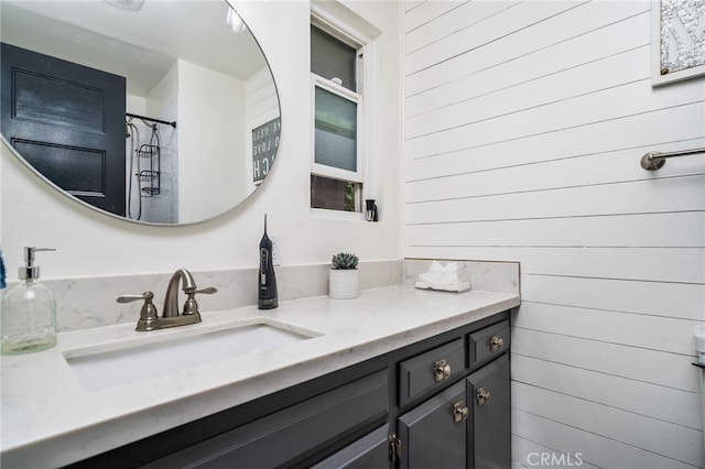 bathroom featuring vanity, walk in shower, and wood walls