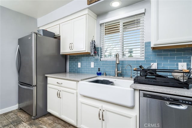 kitchen with sink, dark hardwood / wood-style floors, stainless steel appliances, decorative backsplash, and white cabinets