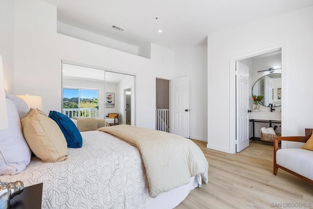 bedroom with connected bathroom and light hardwood / wood-style flooring