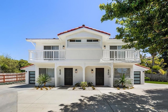 mediterranean / spanish-style home with a garage and a balcony