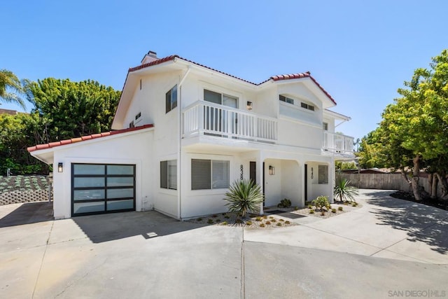 mediterranean / spanish-style house featuring a garage and a balcony