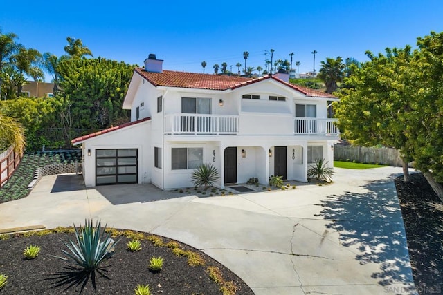 mediterranean / spanish-style home with a garage and a balcony