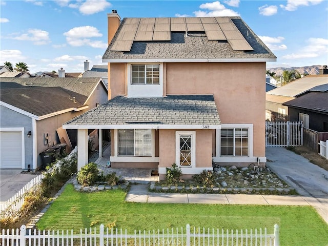 view of front of house featuring a front yard and solar panels