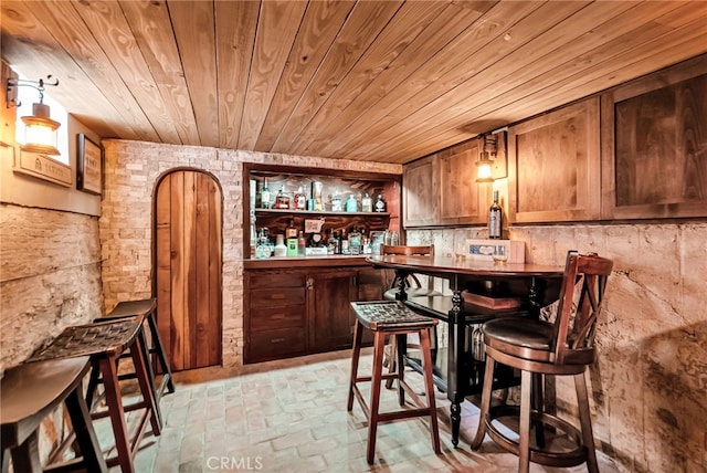 bar featuring wood ceiling and pendant lighting