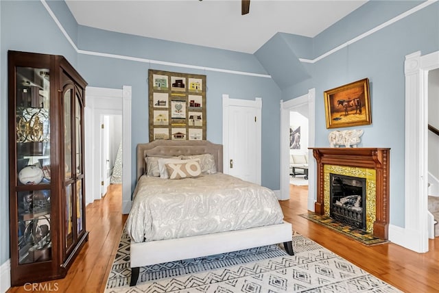 bedroom featuring ceiling fan, lofted ceiling, and light hardwood / wood-style floors