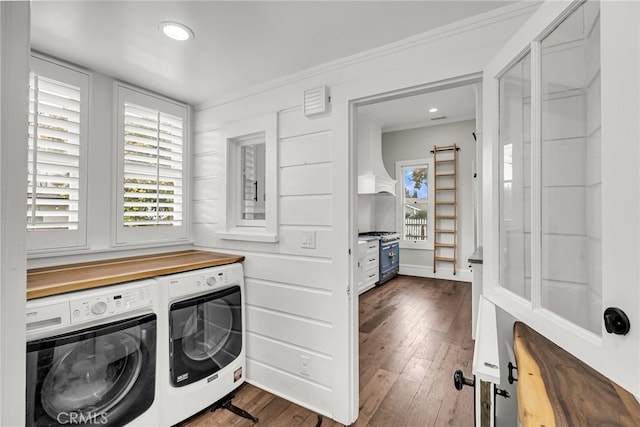 laundry area featuring crown molding, separate washer and dryer, and dark hardwood / wood-style floors