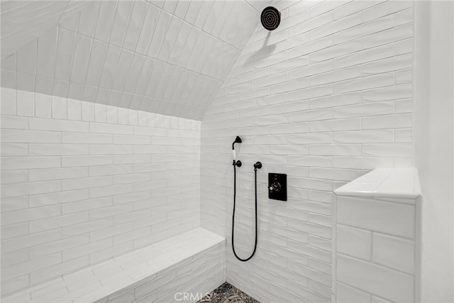 bathroom with lofted ceiling and a tile shower