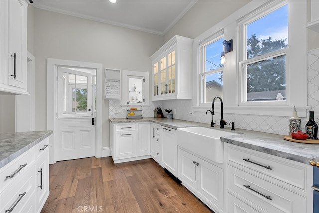 kitchen featuring sink, wood-type flooring, light stone countertops, and white cabinets