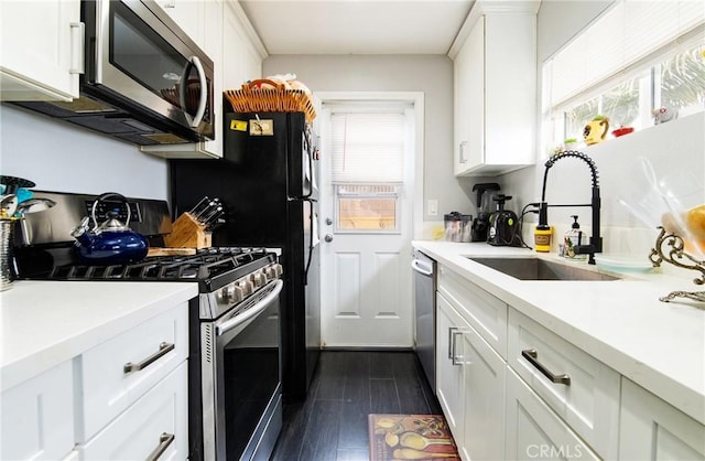 kitchen with white cabinetry, appliances with stainless steel finishes, dark wood-type flooring, and sink