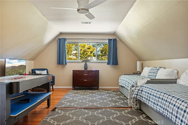 bedroom featuring hardwood / wood-style floors, vaulted ceiling, and ceiling fan