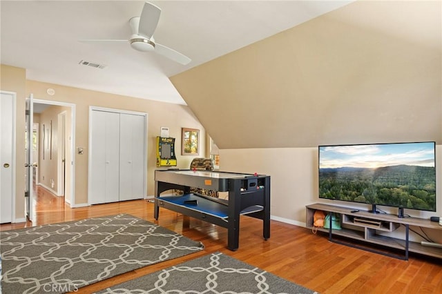 interior space featuring baseboards, visible vents, lofted ceiling, ceiling fan, and wood finished floors