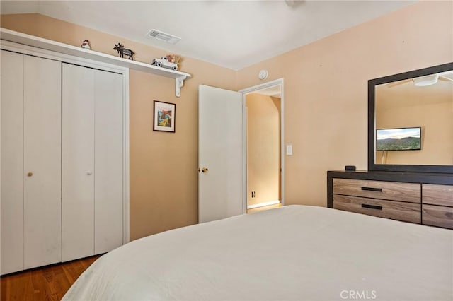 bedroom featuring lofted ceiling, hardwood / wood-style floors, and a closet