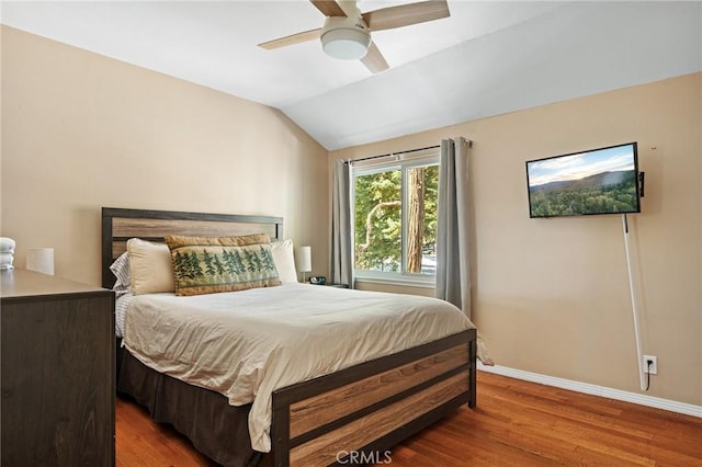 bedroom with ceiling fan, vaulted ceiling, and wood-type flooring