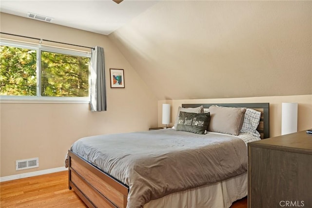 bedroom with lofted ceiling and light hardwood / wood-style flooring