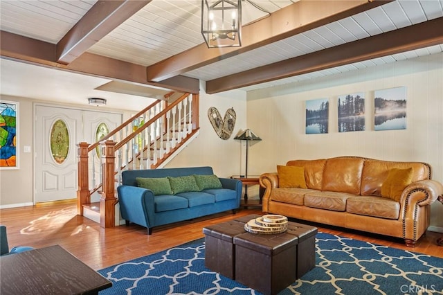 living room featuring hardwood / wood-style flooring, a healthy amount of sunlight, beam ceiling, and an inviting chandelier