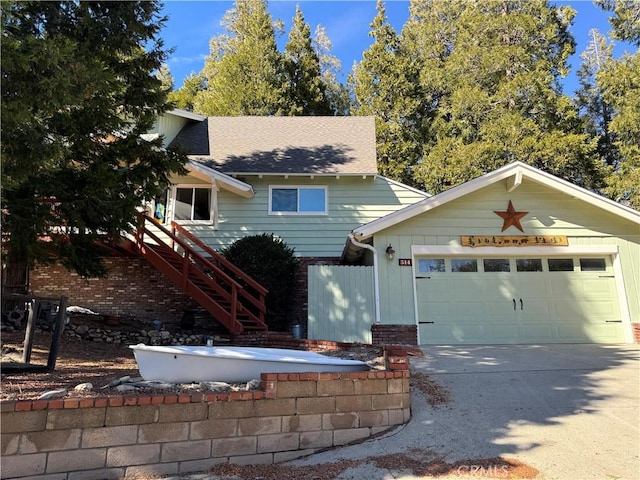 view of front facade featuring brick siding, a shingled roof, concrete driveway, a garage, and stairs