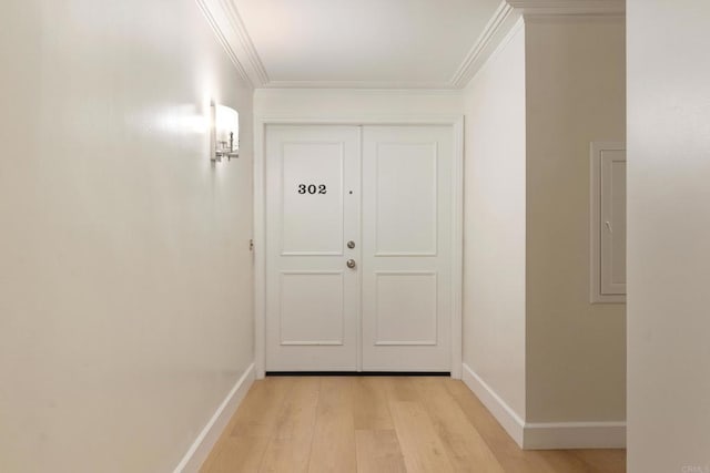 entryway with crown molding and light hardwood / wood-style floors