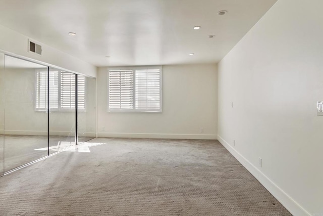 unfurnished bedroom featuring light colored carpet and a closet