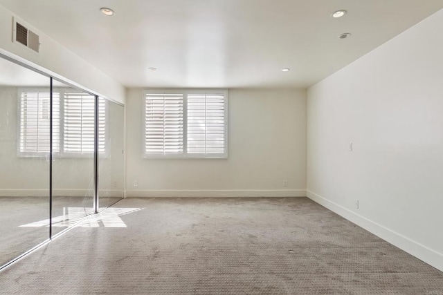 unfurnished bedroom featuring light carpet and a closet