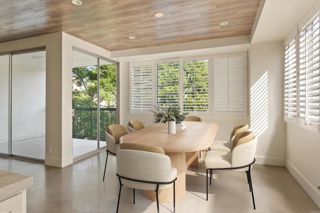 dining room with plenty of natural light, concrete flooring, and wooden ceiling