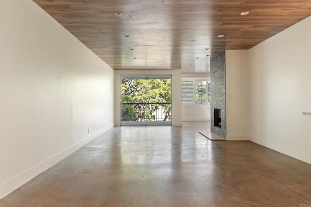 unfurnished living room with wood ceiling, a fireplace, and concrete floors