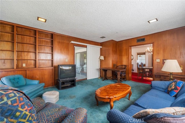 carpeted living room with a textured ceiling and wood walls