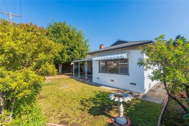 rear view of property featuring a patio and a yard