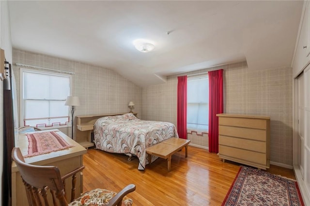 bedroom with vaulted ceiling and light hardwood / wood-style floors