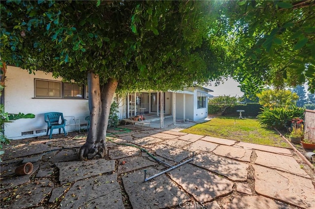 rear view of property with a patio and a lawn