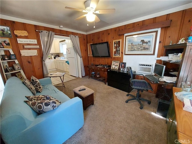 home office featuring wooden walls, ceiling fan, and carpet