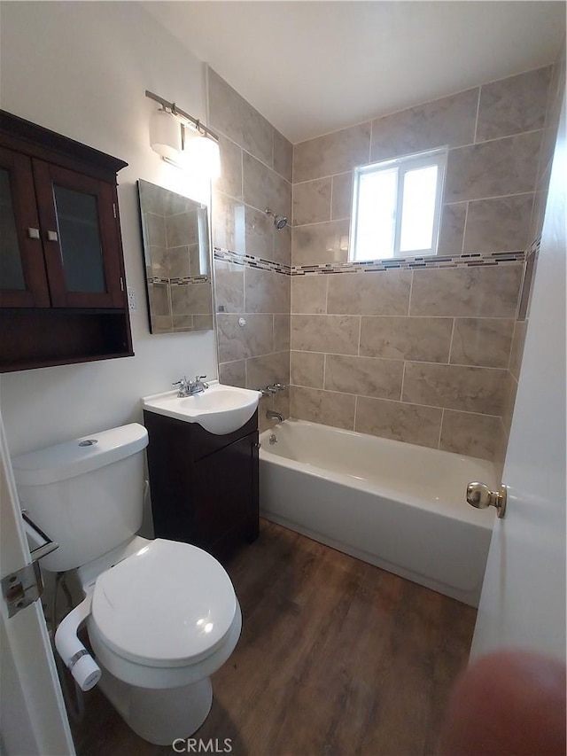 full bathroom featuring vanity, hardwood / wood-style floors, toilet, and tiled shower / bath