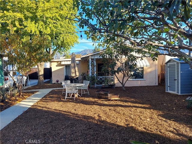 rear view of house featuring a shed and an outdoor fire pit