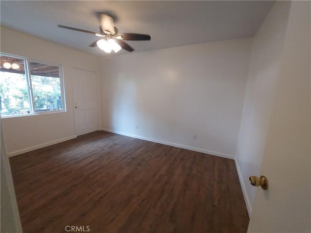 spare room with dark hardwood / wood-style floors and ceiling fan