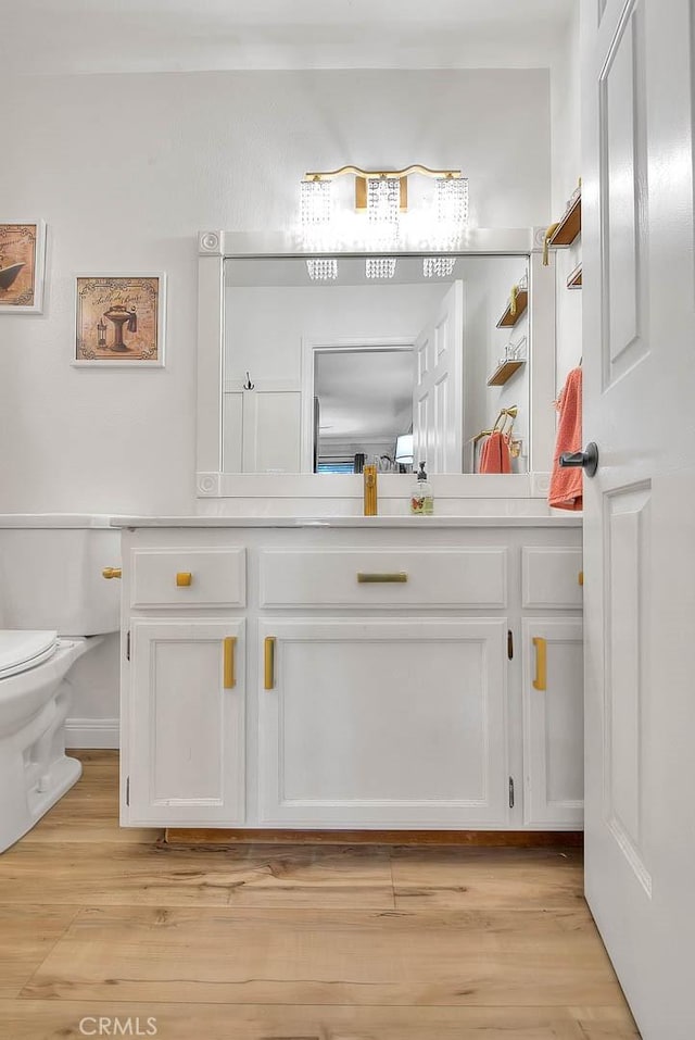 bathroom with vanity, wood-type flooring, and toilet