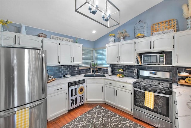 kitchen featuring lofted ceiling, sink, stainless steel appliances, hardwood / wood-style floors, and white cabinets