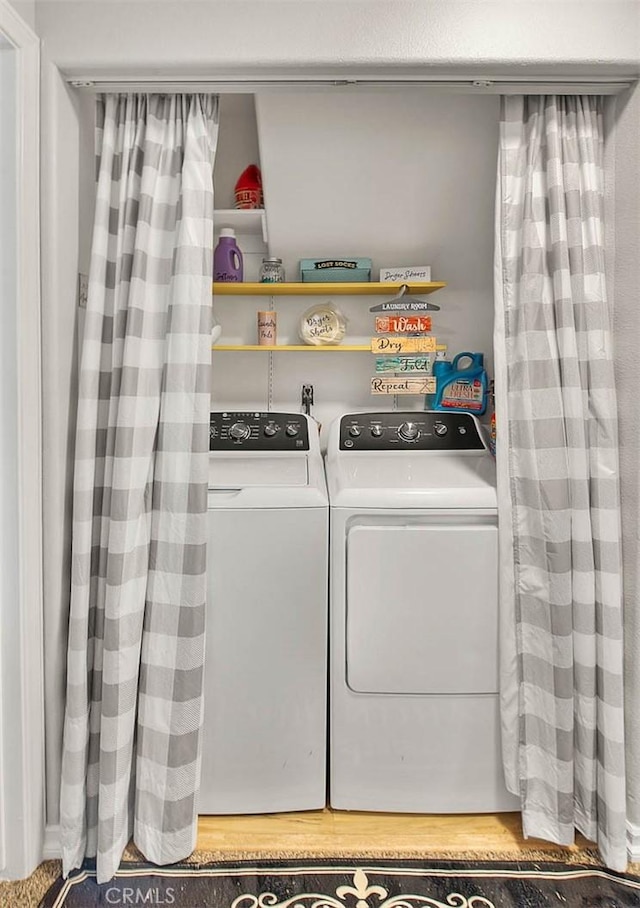 washroom with washer and dryer and light hardwood / wood-style flooring