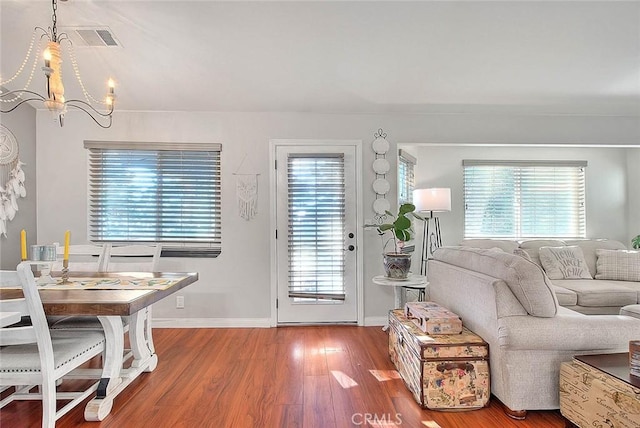 living room featuring hardwood / wood-style flooring, an inviting chandelier, and a wealth of natural light