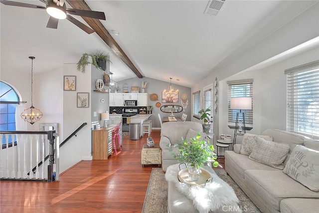 living room with dark hardwood / wood-style flooring, ceiling fan with notable chandelier, and vaulted ceiling with beams