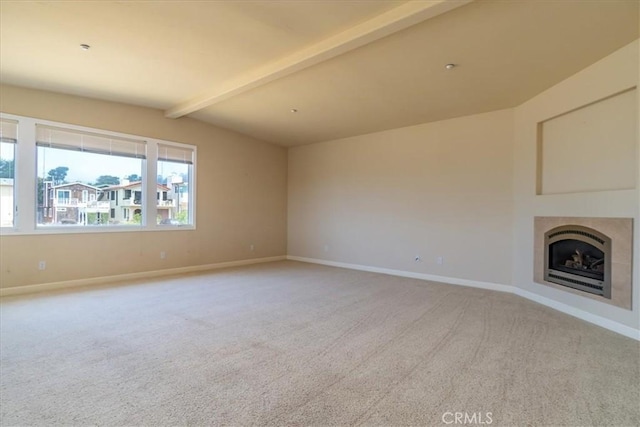 unfurnished living room featuring a tiled fireplace, lofted ceiling with beams, and light carpet