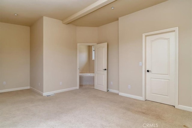 empty room featuring beamed ceiling and light colored carpet