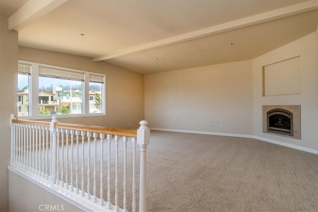 unfurnished living room featuring vaulted ceiling with beams and carpet flooring