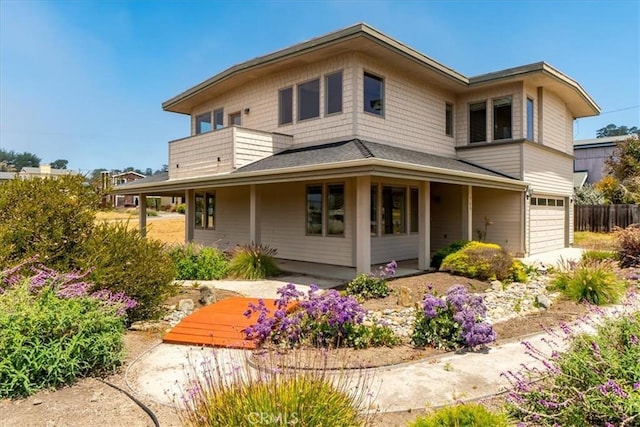 back of house with a garage and a balcony