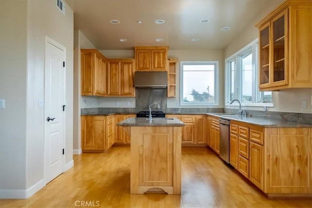 kitchen with dishwasher, sink, a center island with sink, and light hardwood / wood-style floors