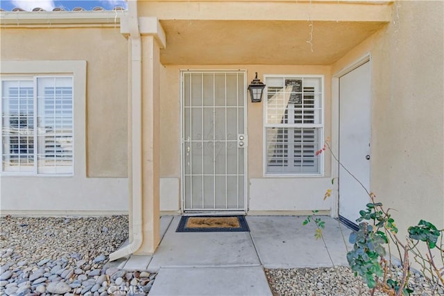 view of exterior entry with a patio