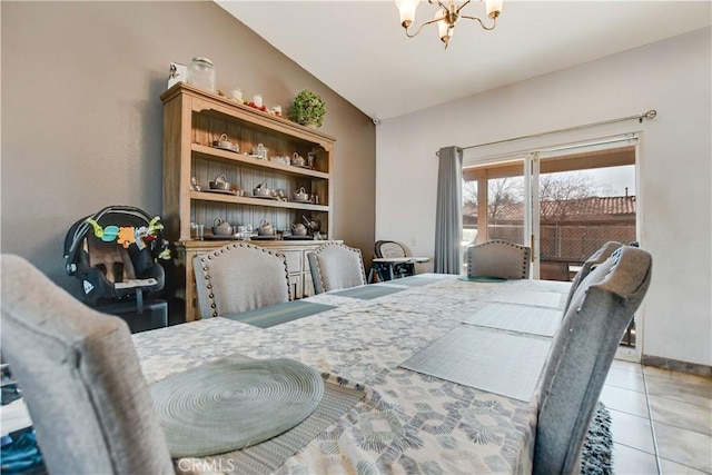 dining space featuring an inviting chandelier, light tile patterned flooring, and vaulted ceiling